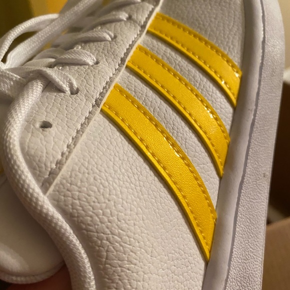 white adidas with yellow stripes